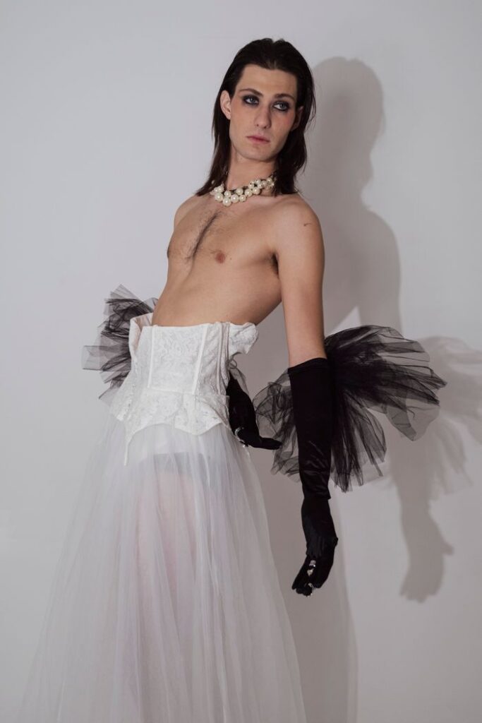 pexels photo 28262915 28262915 A model wearing a white tulle skirt, black gloves, and pearl necklace in a studio fashion shoot.